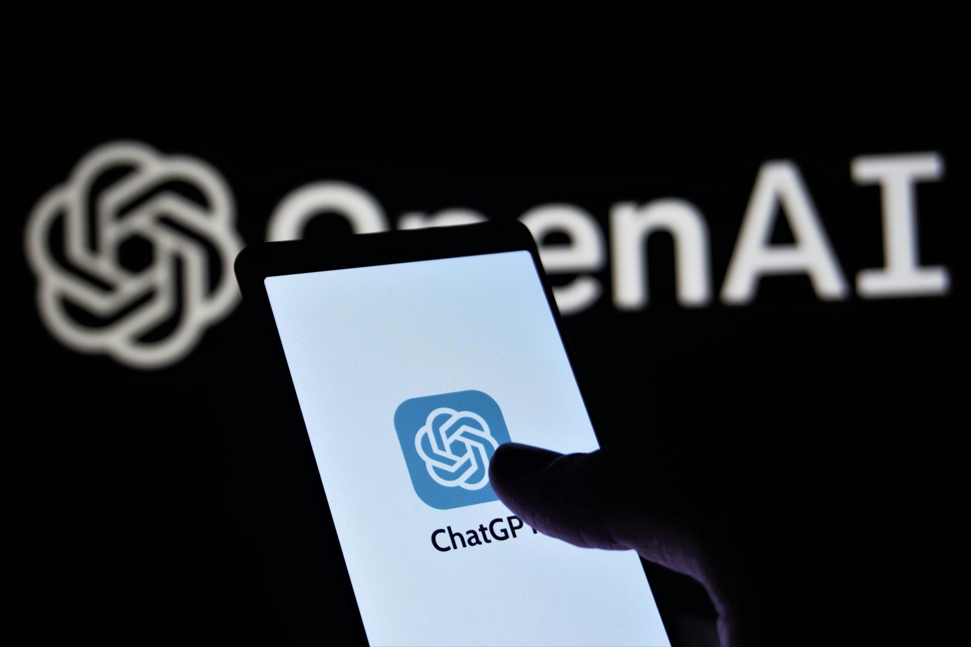 Person holding phone with ChatGPT logo displayed